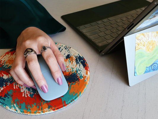 Hand on a SLChristley Designs Abstract Horizons mousepad with the Spiral Sunlit Flow sticker on the back of a laptop