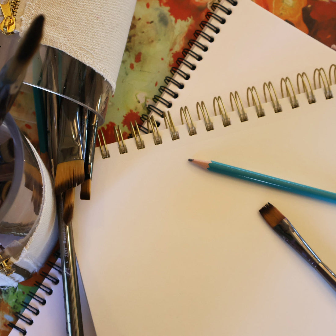 Creative art supplies flatlay with sketchpads, pencils, and art brushes.